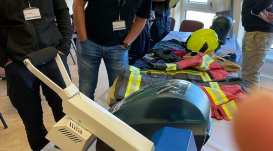 Ausgebreitete PSA wird begutachtet, die abgebildeten Personen im Vordergrund haben ein sehr amüsantes Gespräch